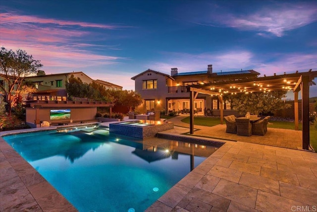 pool at dusk with an outdoor living space, a patio area, and an in ground hot tub