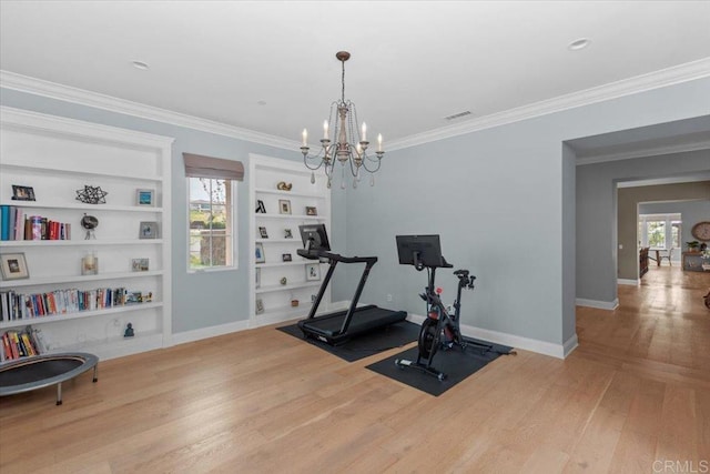 exercise room with light wood-type flooring, built in features, crown molding, and a chandelier