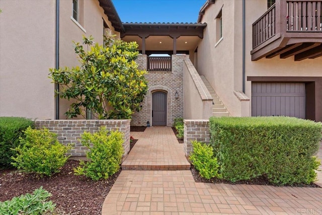 property entrance with a balcony and a garage