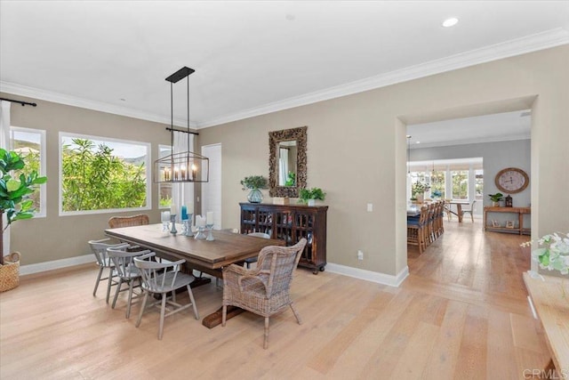 dining area featuring a chandelier, crown molding, and light hardwood / wood-style flooring