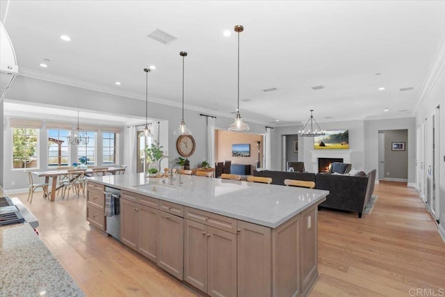 kitchen featuring dishwasher, sink, hanging light fixtures, ornamental molding, and light stone counters