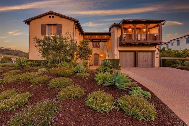 mediterranean / spanish-style house with a garage and a balcony