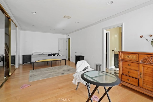 sitting room with crown molding and light hardwood / wood-style floors