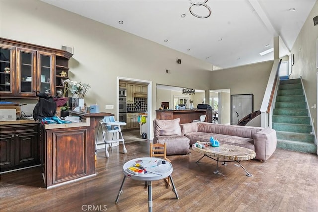 living room with a high ceiling and dark wood-type flooring