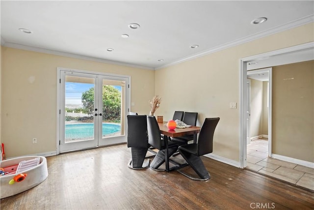 dining space with hardwood / wood-style floors, ornamental molding, and french doors