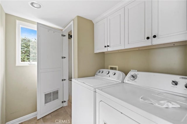 laundry room featuring cabinets, light tile patterned floors, and washing machine and clothes dryer