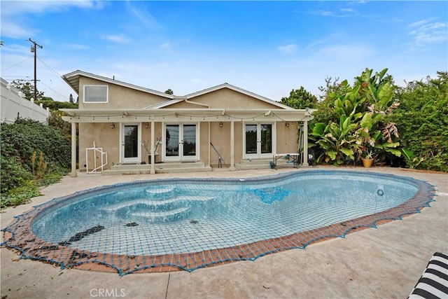 view of pool with french doors and a patio area