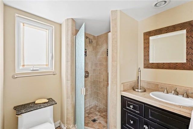 bathroom featuring a shower with shower door and vanity