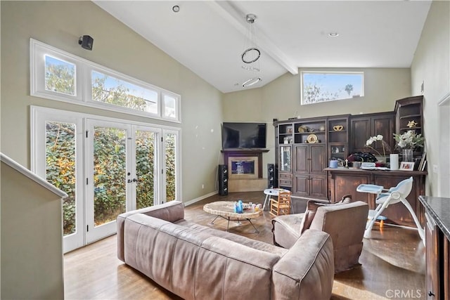 living room with light wood-type flooring, beam ceiling, french doors, and high vaulted ceiling