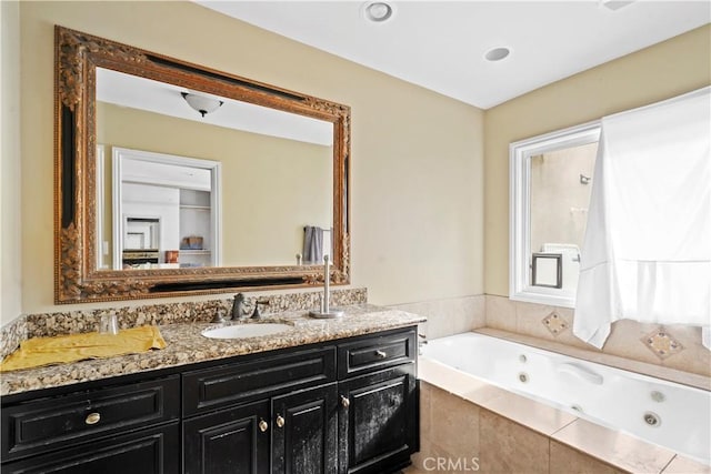 bathroom featuring vanity and tiled tub