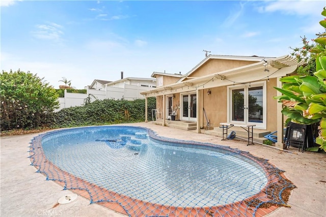 view of swimming pool with french doors and a patio