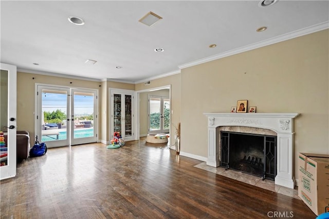 unfurnished living room with hardwood / wood-style flooring, crown molding, french doors, and a fireplace