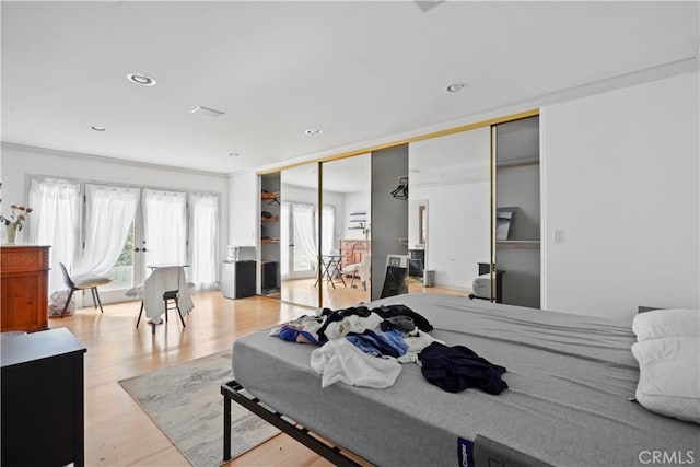 bedroom featuring light hardwood / wood-style floors, a closet, and ornamental molding