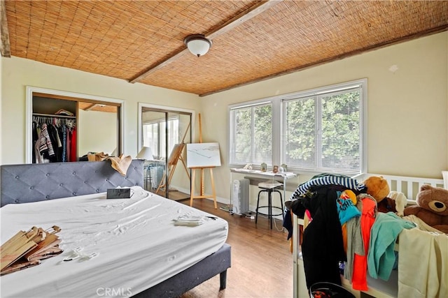 bedroom featuring wood ceiling, radiator heating unit, and hardwood / wood-style flooring