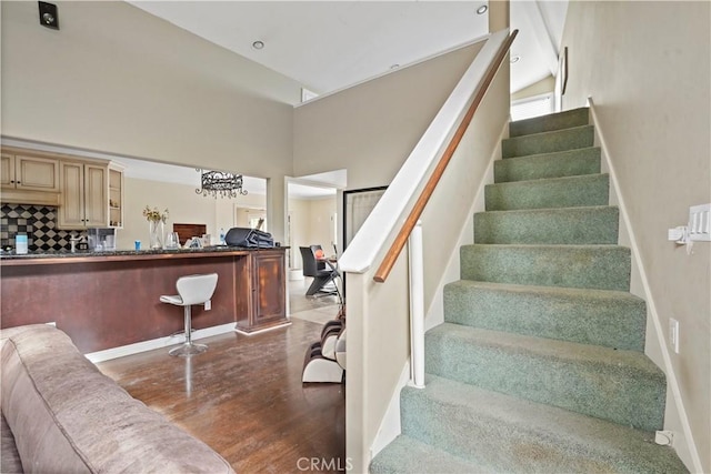 stairway featuring hardwood / wood-style floors and a towering ceiling