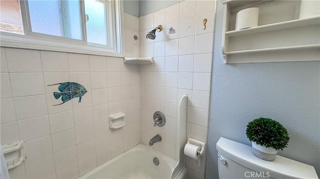 bathroom with tiled shower / bath combo and toilet