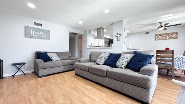 living room featuring ceiling fan and light hardwood / wood-style floors