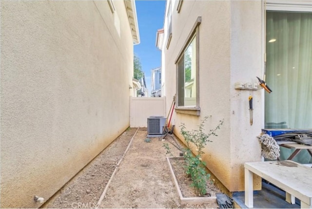 view of property exterior with cooling unit and a patio area