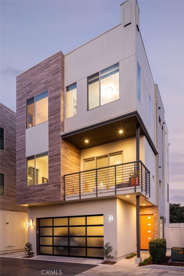 contemporary home featuring a garage and a balcony