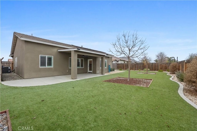 rear view of property featuring a lawn, central AC, and a patio area