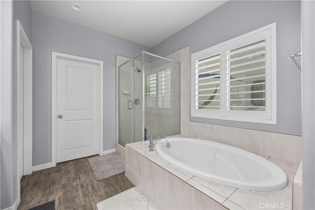 bathroom featuring plus walk in shower and hardwood / wood-style flooring