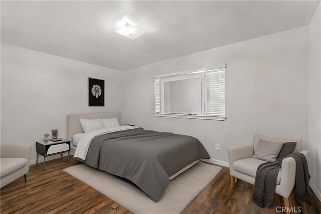 bedroom with dark hardwood / wood-style floors