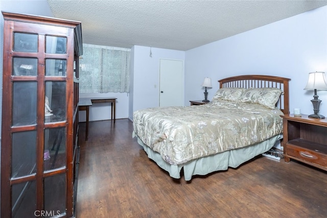 bedroom with a textured ceiling and wood finished floors