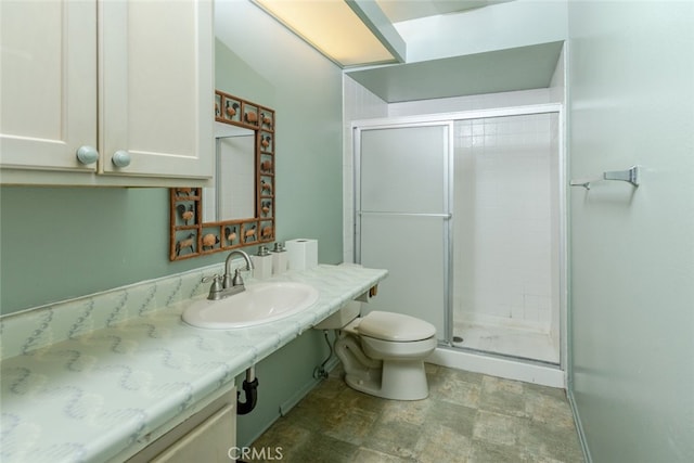 bathroom with toilet, sink, and a shower with shower door