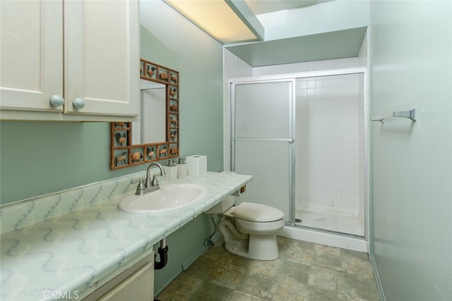 full bath with a stall shower, stone finish flooring, vanity, and toilet