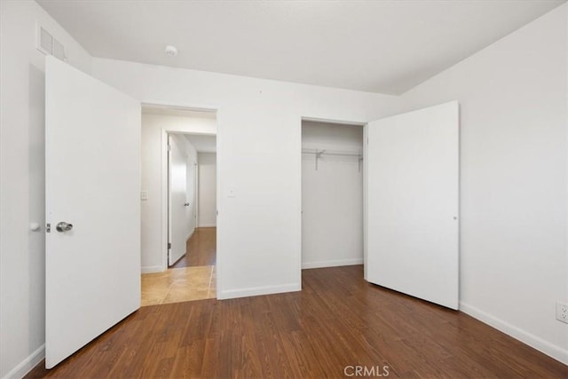 unfurnished bedroom with a closet and hardwood / wood-style floors