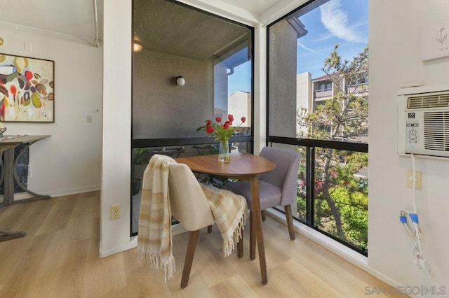 dining space with light wood-type flooring, a wall of windows, and plenty of natural light