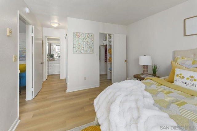 bedroom with light wood-type flooring, a closet, and a spacious closet