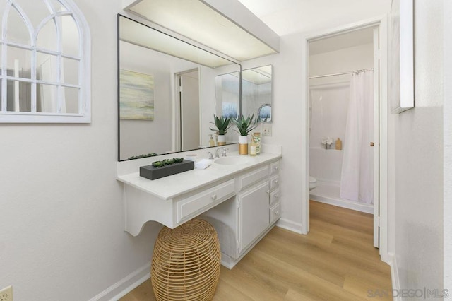 bathroom with vanity, toilet, hardwood / wood-style floors, and walk in shower