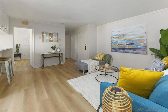 living room with ornamental molding and light hardwood / wood-style floors