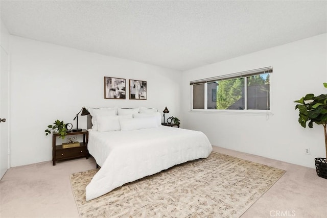 bedroom featuring light colored carpet and a textured ceiling