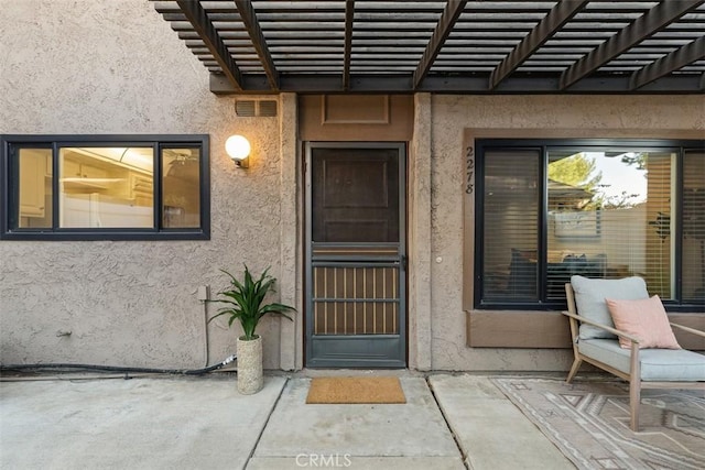 property entrance with a patio and a pergola