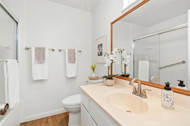 bathroom featuring vanity, hardwood / wood-style flooring, toilet, and walk in shower