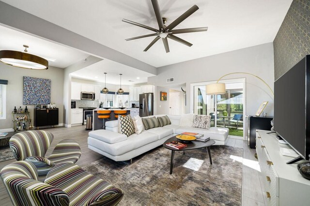 living room featuring ceiling fan and dark wood-type flooring