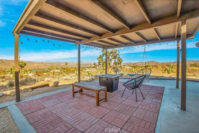 view of patio / terrace with a mountain view and a fire pit