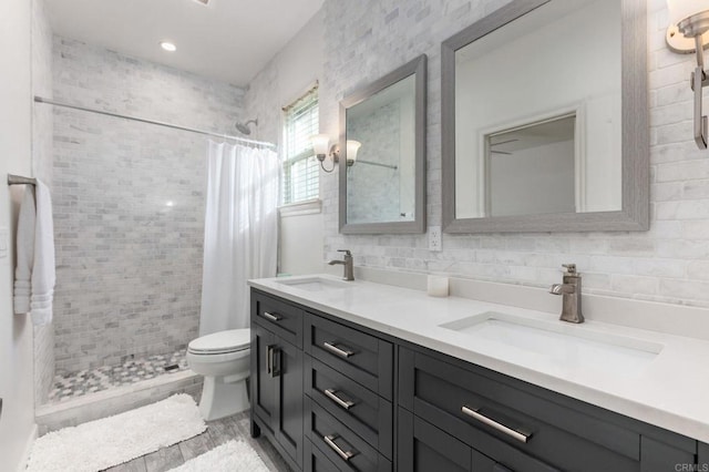 bathroom featuring toilet, decorative backsplash, a shower with curtain, and vanity