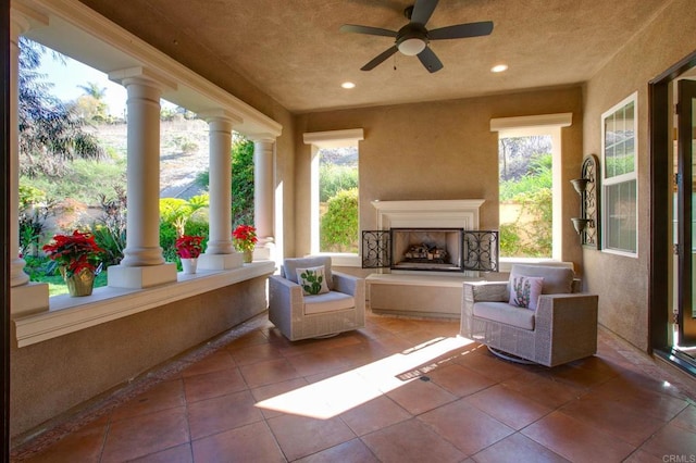 view of patio featuring ceiling fan and exterior fireplace