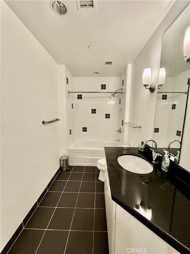 full bathroom with toilet, tile patterned floors, tiled shower / bath, and vanity