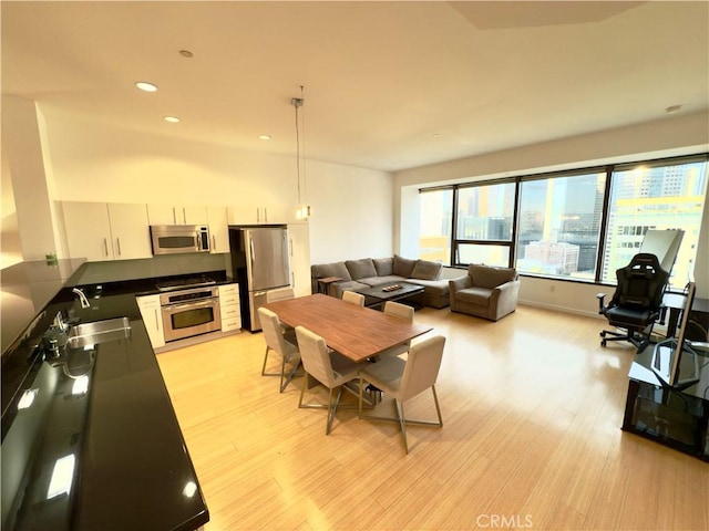 dining space with sink and light hardwood / wood-style floors