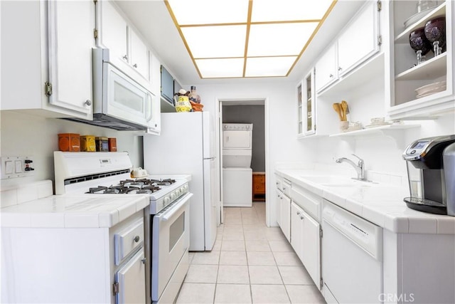 kitchen with sink, white appliances, white cabinets, and tile counters