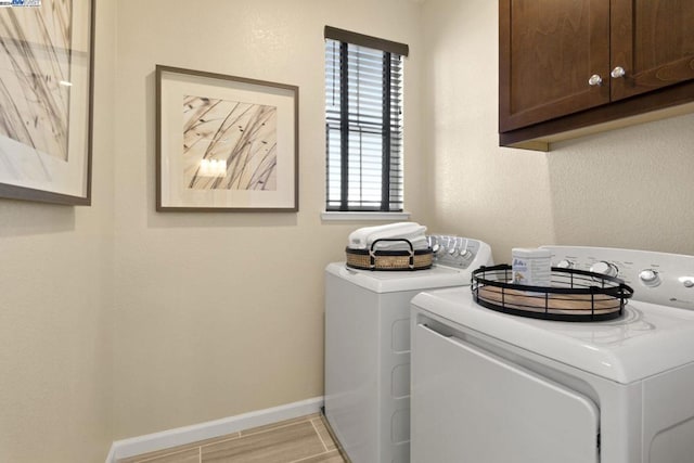 clothes washing area featuring washer and dryer and cabinets