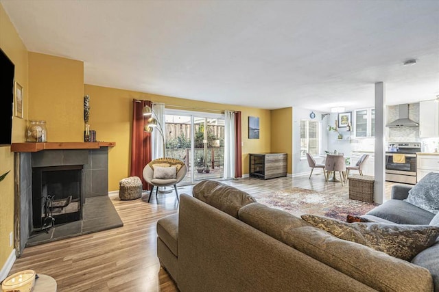 living room featuring light wood-type flooring and a fireplace