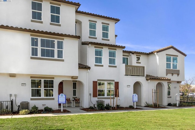 mediterranean / spanish home with cooling unit and a front lawn