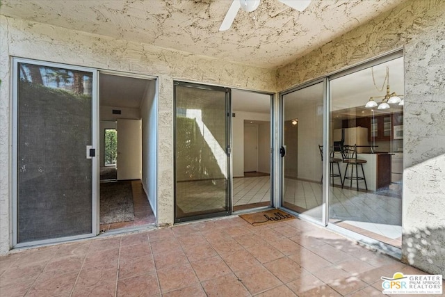 entrance to property featuring ceiling fan and a patio area