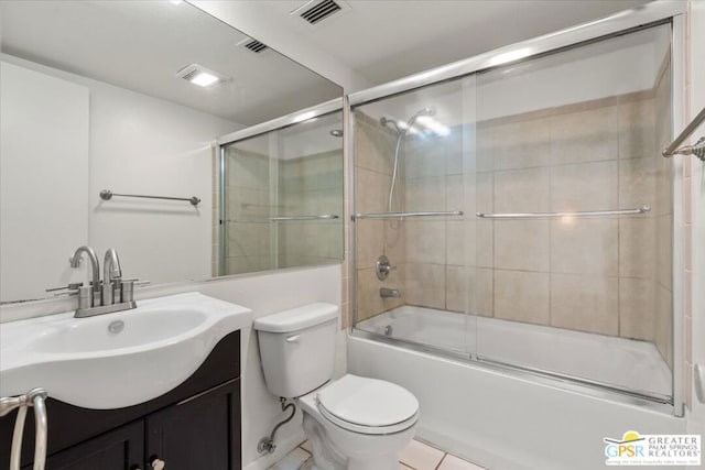 full bathroom with combined bath / shower with glass door, vanity, tile patterned flooring, and toilet