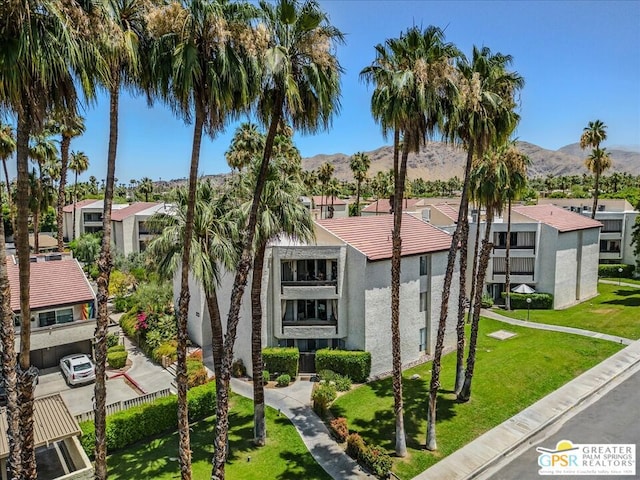 view of front of house with a front lawn and a mountain view